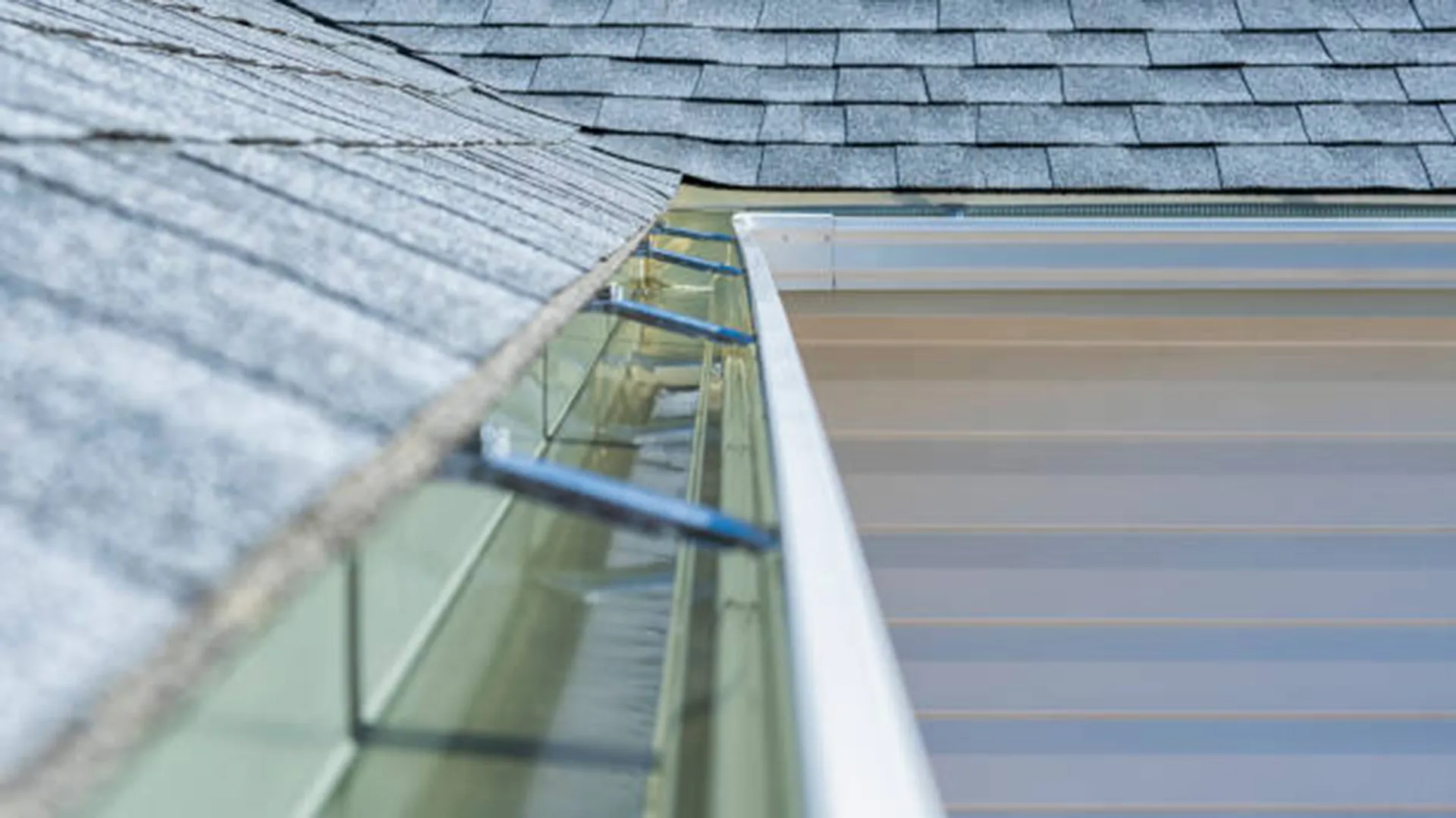 gutter hangers shingle edge closeup by American Home Contractors near McLean